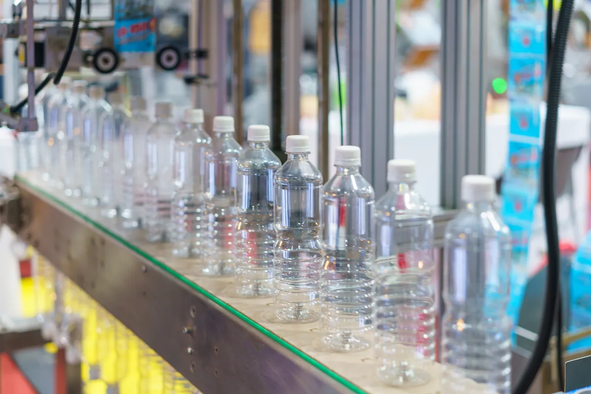 Bottles moving along a consumer goods production line